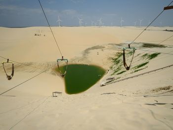 Ski lift cables leading towards lake at desert