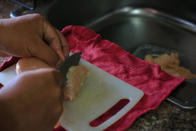 Midsection of person holding ice cream in kitchen
