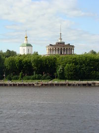 View of building by river against sky