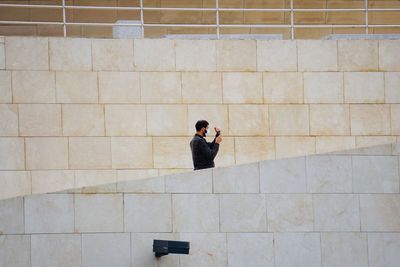 Rear view of man standing against wall