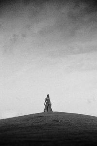 Woman standing on sand against sky