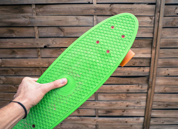 Low section of baby hand on wood