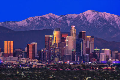 Illuminated buildings in city against sky