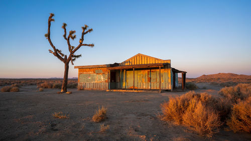 House on field against clear sky
