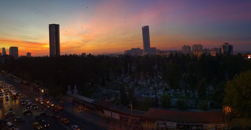 Skyscrapers in city at sunset