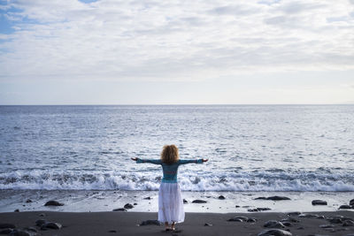 Rear view of woman looking at sea against sky