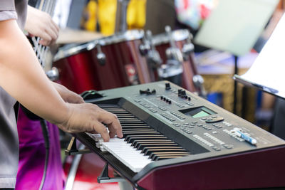 Midsection of man playing piano