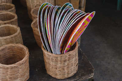 Close-up of bamboo hand fans in wicker basket at store