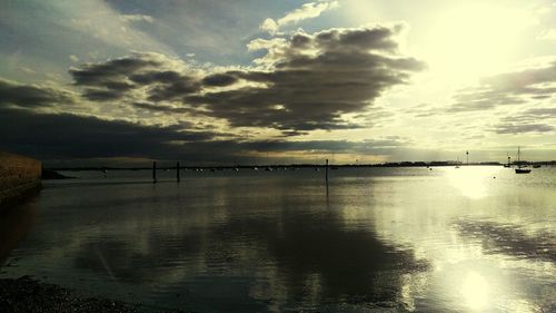 Scenic view of sea against cloudy sky during sunset