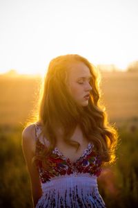 Portrait of woman standing on field against sky