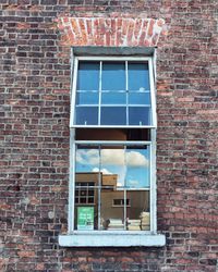 Low angle view of window on brick wall of building