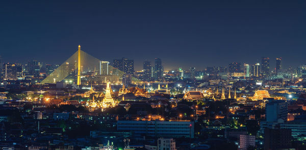 Illuminated cityscape against sky at night