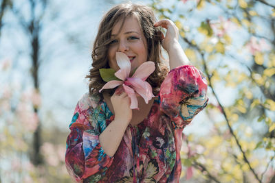 Portrait of smiling woman holding flower