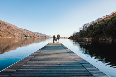 Father, mother and daughter on a pier on lake mergozzo