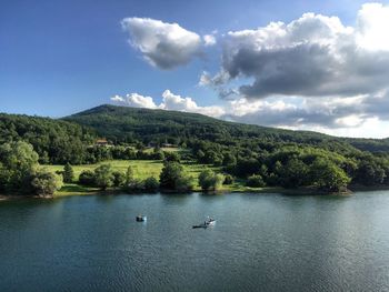 Scenic view of river and mountains against sky