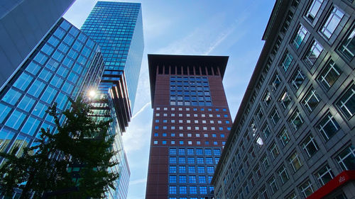 Low angle view of modern buildings against blue sky