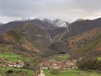 Scenic view of townscape and mountains against sky