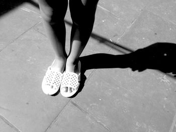 Low section of woman standing on footpath