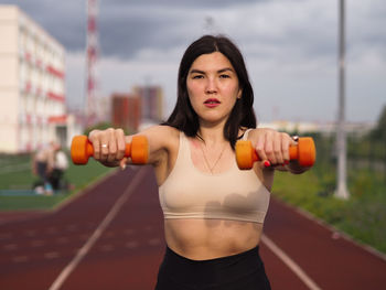 Portrait of young woman exercising in gym