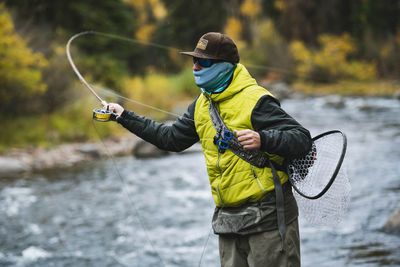 Man fly fishing at roaring fork river in forest