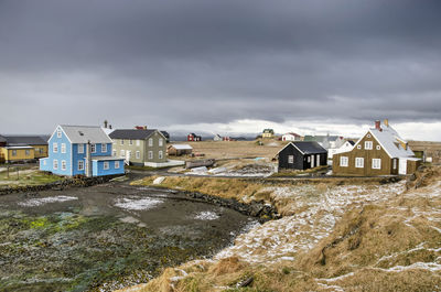Dark clouds of a recent snow storm still loom over the village while snow is melting on the fields