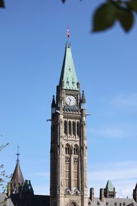 Low angle view of clock tower amidst buildings against sky