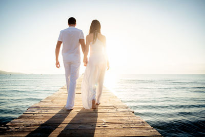 Rear view of couple standing in sea