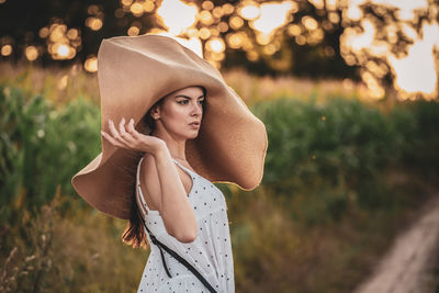 Young woman wearing hat standing outdoors