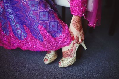 Low section of woman standing on pink fabric