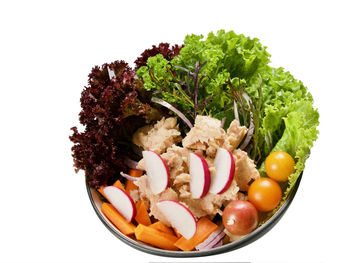 Close-up of fresh vegetables in plate against white background