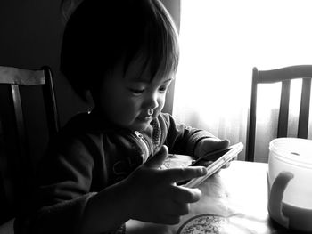 Close-up of cute baby girl using mobile phone at table