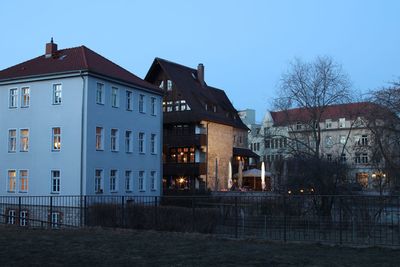 Illuminated buildings against sky at dusk