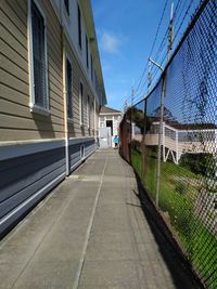 Rear view of boy walking on walkway by building