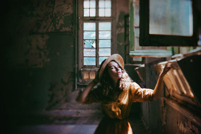 Girl in old derelict building with sunlight streaming in