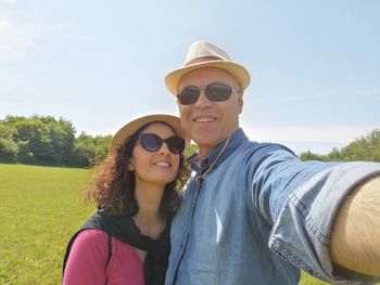 Portrait of smiling young woman wearing sunglasses against sky