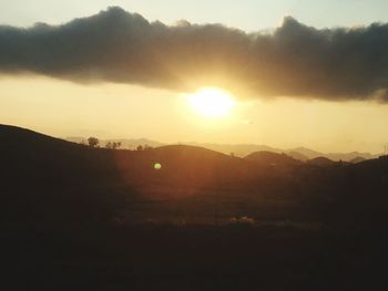 Scenic view of silhouette mountains against sky during sunset