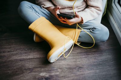 Girl using mobile phone while sitting on floor at home