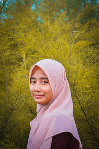 Portrait of woman in hijab by plants