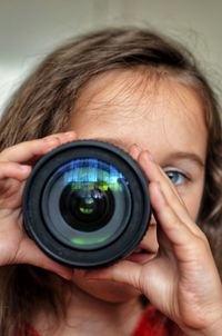 Close-up portrait of girl holding camera