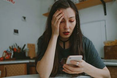 Young beautiful woman with the smartphone at home