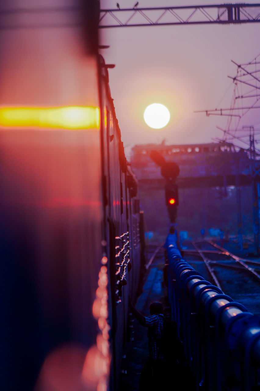 ILLUMINATED LIGHTS AGAINST SKY AT SUNSET