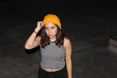 Portrait of young woman standing on floor