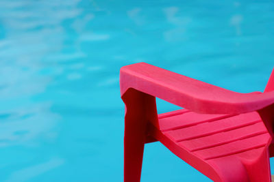 Close-up of chair against swimming pool