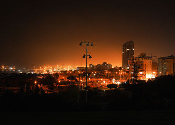 Illuminated buildings against sky at night