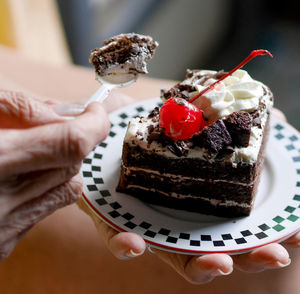 Cropped hand of woman holding cake