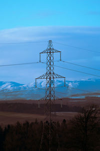 Low angle view of electricity pylon against sky