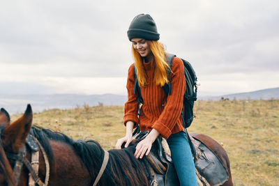 Young woman riding horse in a field