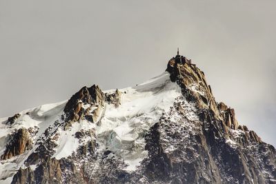 Low angle view of snowcapped mountains against clear sky