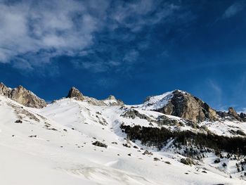 Scenic view of snowcapped mountains against blue sky