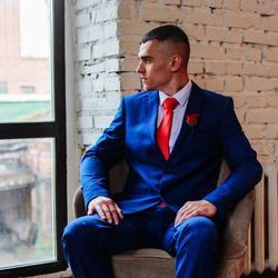 Man looking away while sitting on chair against window